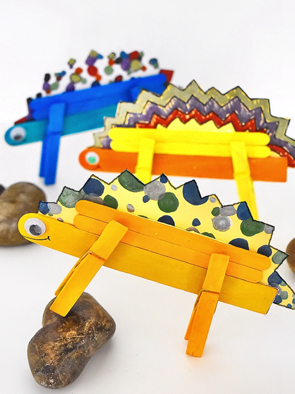 Child's handmade Stegosaurus dinosaur using craft sticks and clothespins