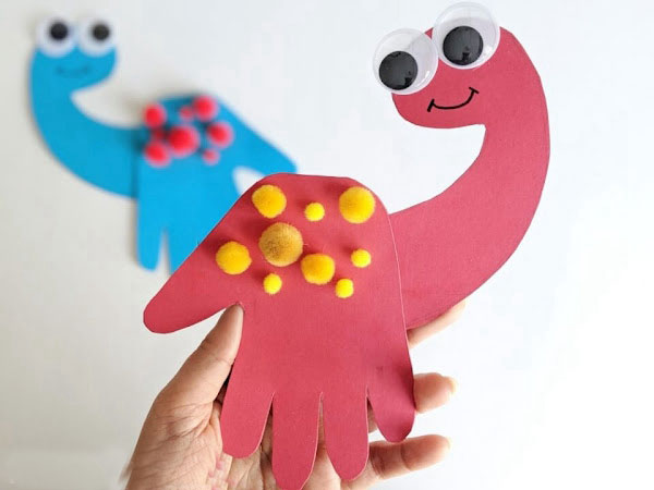 Child's handprint transformed into a dinosaur on a card