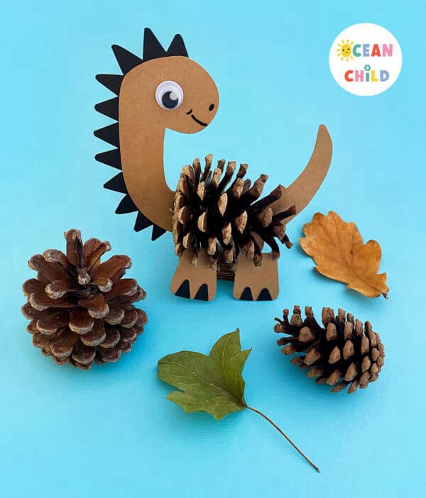 Colorful pinecone dinosaurs made by kids as a fall craft activity