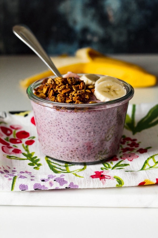 Blueberry Yogurt Chia Pudding topped with banana, granola, and nut butter in a bowl.