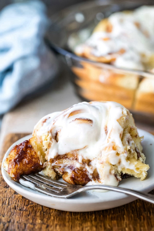 A batch of homemade cinnamon rolls, fluffy and sweet, topped with creamy frosting, reminiscent of Cinnabon's famous treat.