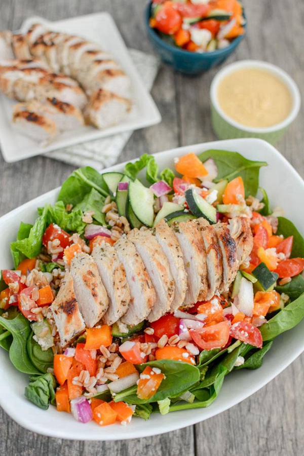 A vibrant Mediterranean Turkey Spinach Salad with grilled turkey and fresh vegetables.