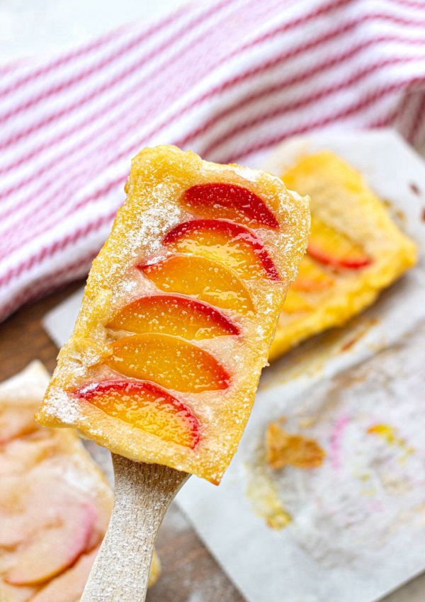 Juicy peach slices atop golden puff pastry, capturing the essence of summer.